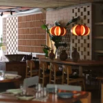 Dining room with orange melon lanterns, earthenware jugs and a brick lattice screen at SPOT Palma De Mallorca