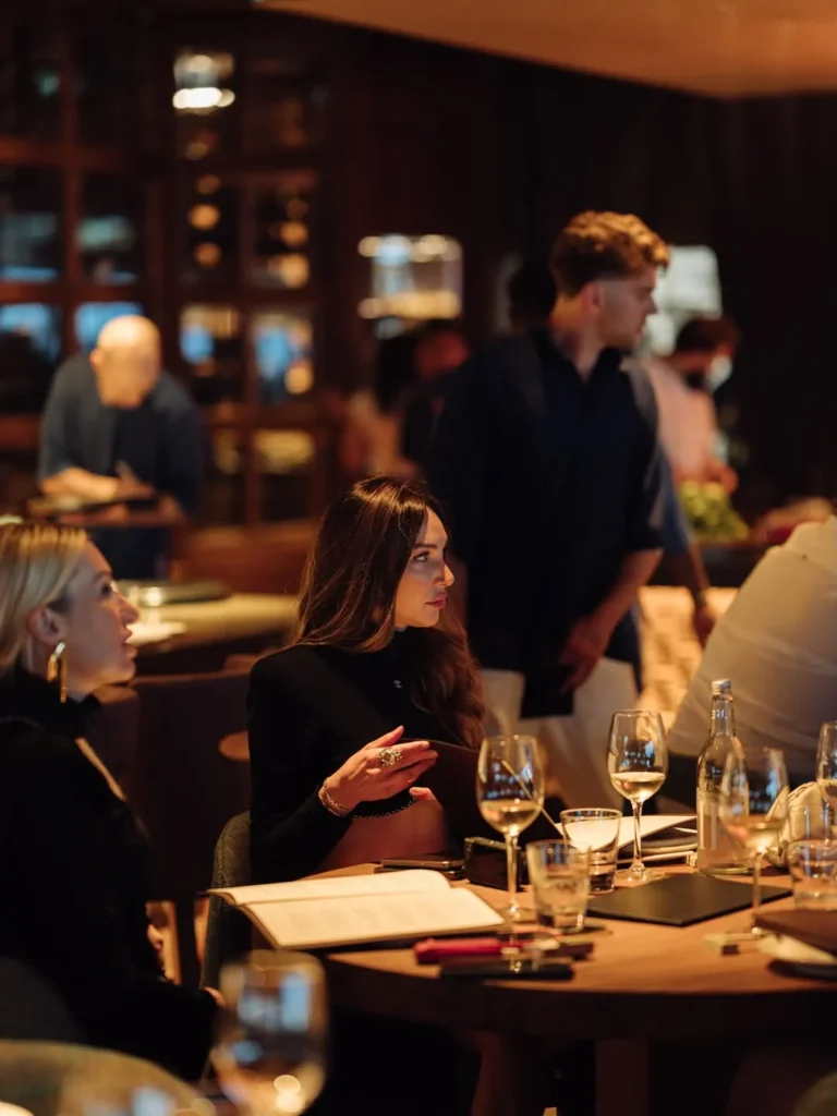 Guest seated at a candlelit table in the busy dining room at Zuma Cannes