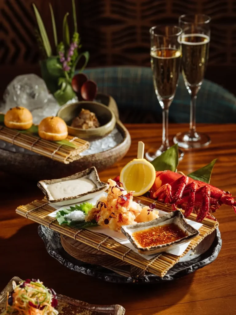 Lobster tempura platter served with dipping sauces and champagne at Zuma Cannes