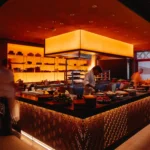 Chef cooking over the open flame of the robata grill in the show kitchen at Zuma Cannes