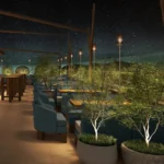 Rooftop terrace with blue armchairs, planted trees and torch lights under a starry sky at Zuma Cannes