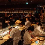 Chefs preparing sushi behind the counter in the dining room at Zuma Cannes