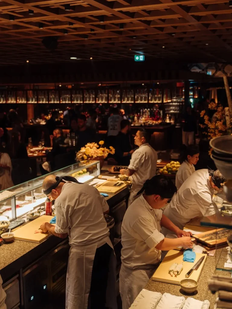 Chefs preparing sushi behind the counter in the dining room at Zuma Cannes