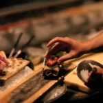 Chef plating caviar-topped nigiri at the sushi counter at Zuma Cannes