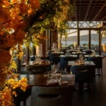 Terrace tables framed by flowers with a sea view at Zuma Cannes