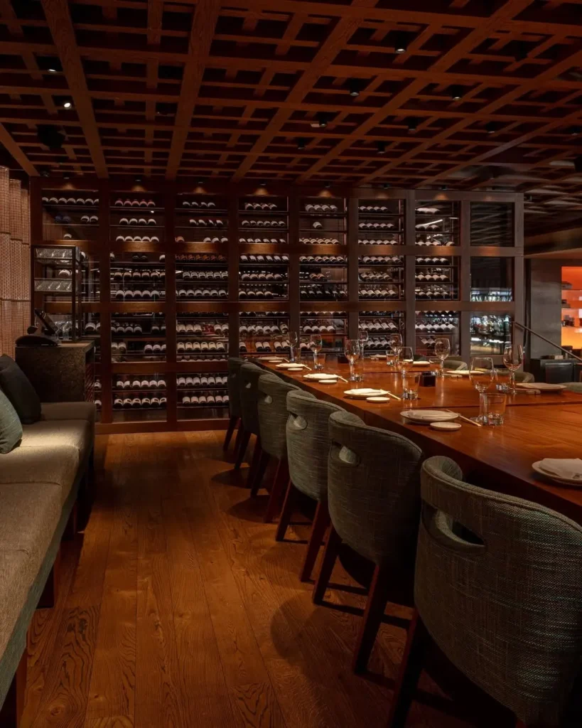 Private dining table beside a floor-to-ceiling wine wall at Zuma Cannes