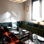 Elegant dining area with marble walls and red chairs at Beefbar Paris