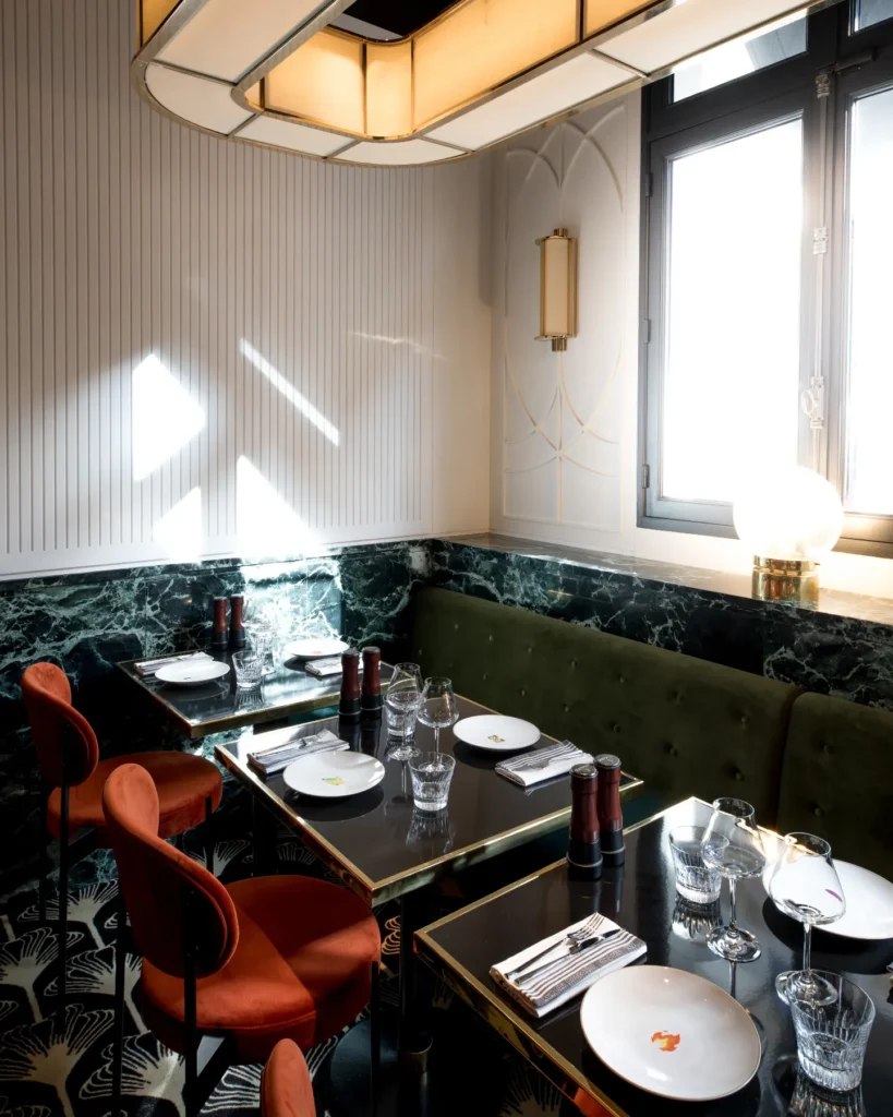 Elegant dining area with marble walls and red chairs at Beefbar Paris