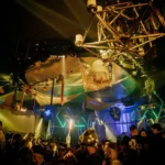 Colorfully illuminated interior and crowd at Boum Boum Paris