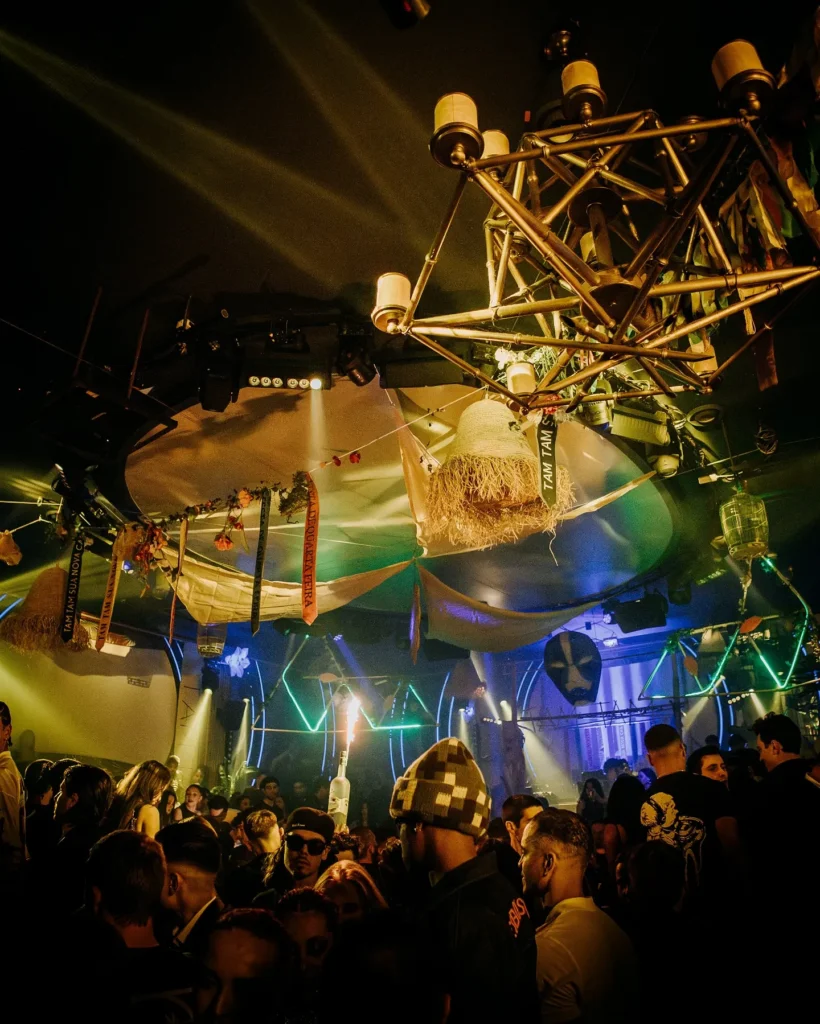 Colorfully illuminated interior and crowd at Boum Boum Paris