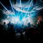 Crowd dancing beneath blue and white lights at Boum Boum Paris