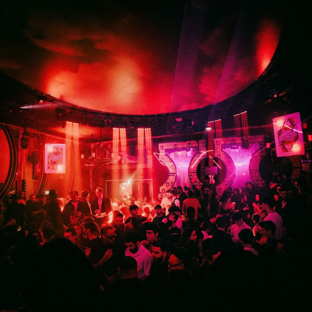 Crowded dance floor under red lighting at Boum Boum Paris