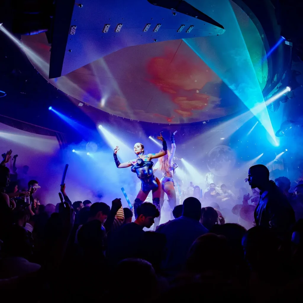 DJ performing to a crowd under blue lights at Boum Boum Paris