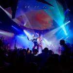 DJ performing to a crowd under blue lights at Boum Boum Paris