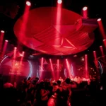 Crowd enjoying the red-lit atmosphere inside Boum Boum Paris