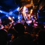 Crowd enjoying the colorful nightlife atmosphere at Deflower Paris