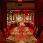 Elegant red-lit dining room at El Porteño Prohibido
