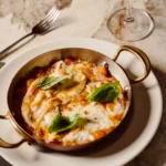 Baked Italian dish topped with cheese and herbs at Giulia Ristorante Paris
