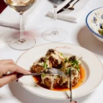 Gourmet plated dish served with wine at Giulia Ristorante Paris