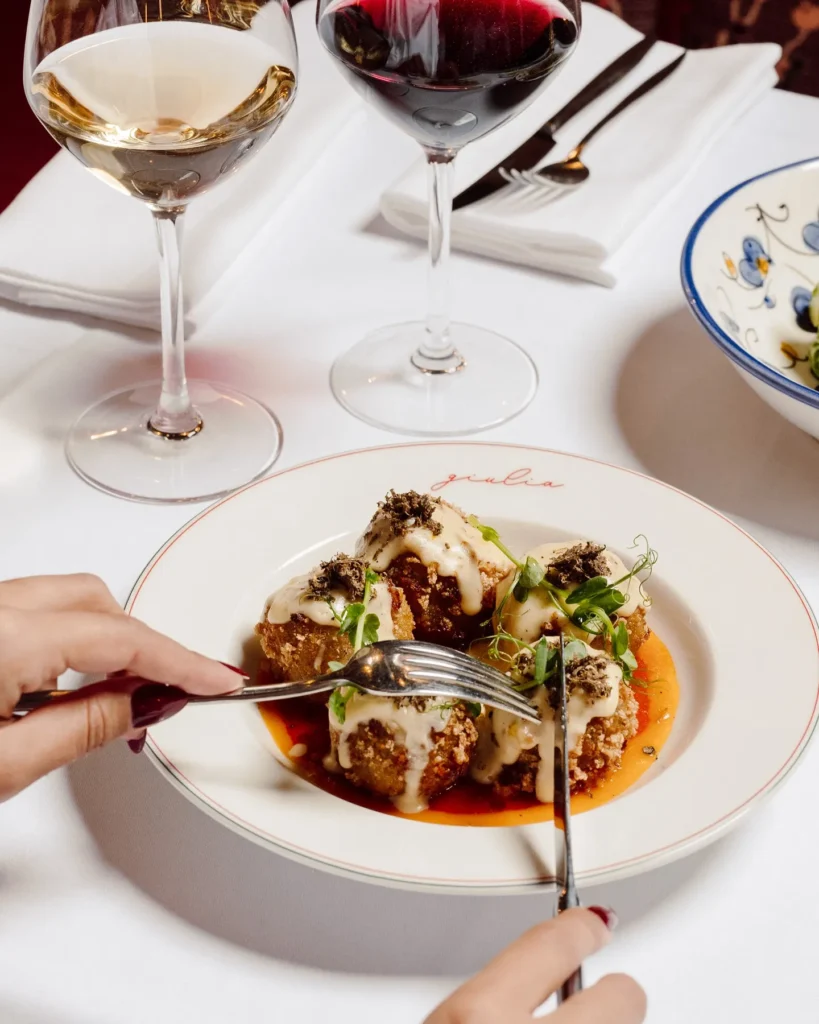 Gourmet plated dish served with wine at Giulia Ristorante Paris
