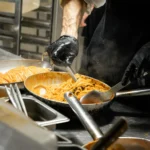 Chef preparing Italian dishes in the kitchen at Giulia Ristorante Paris