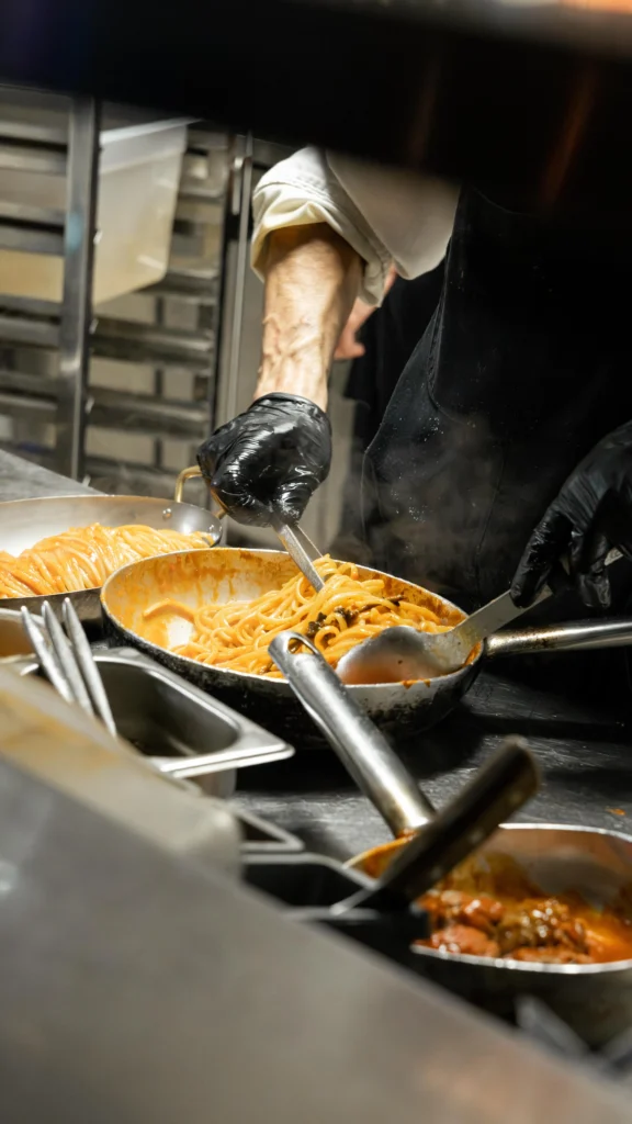 Chef preparing Italian dishes in the kitchen at Giulia Ristorante Paris