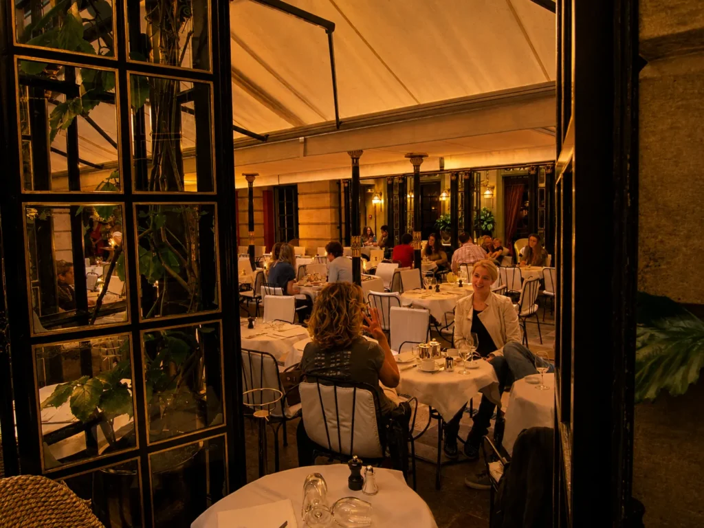 Covered dining terrace at Hotel Costes filled with elegant tables