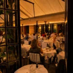 Covered dining terrace at Hotel Costes filled with elegant tables