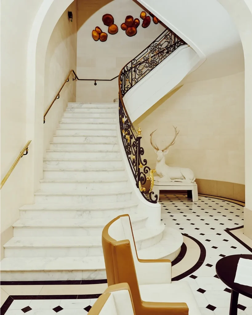 Grand white staircase with ornate details at Hotel Costes Paris
