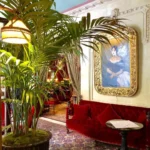 Elegant lounge with red seating and tropical plants at Hotel Costes