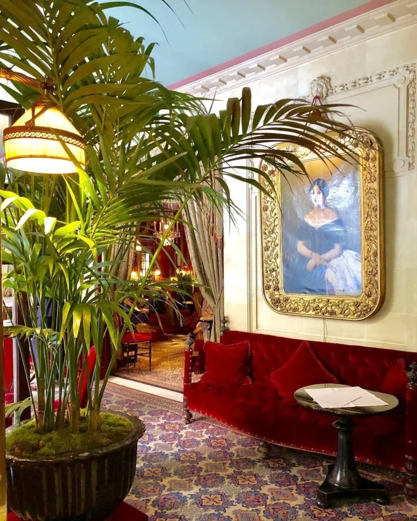 Elegant lounge with red seating and tropical plants at Hotel Costes