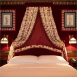 Luxurious red canopy bed in a classic Hotel Costes bedroom