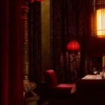 Intimate red dining room with velvet seating at Hotel Costes Paris