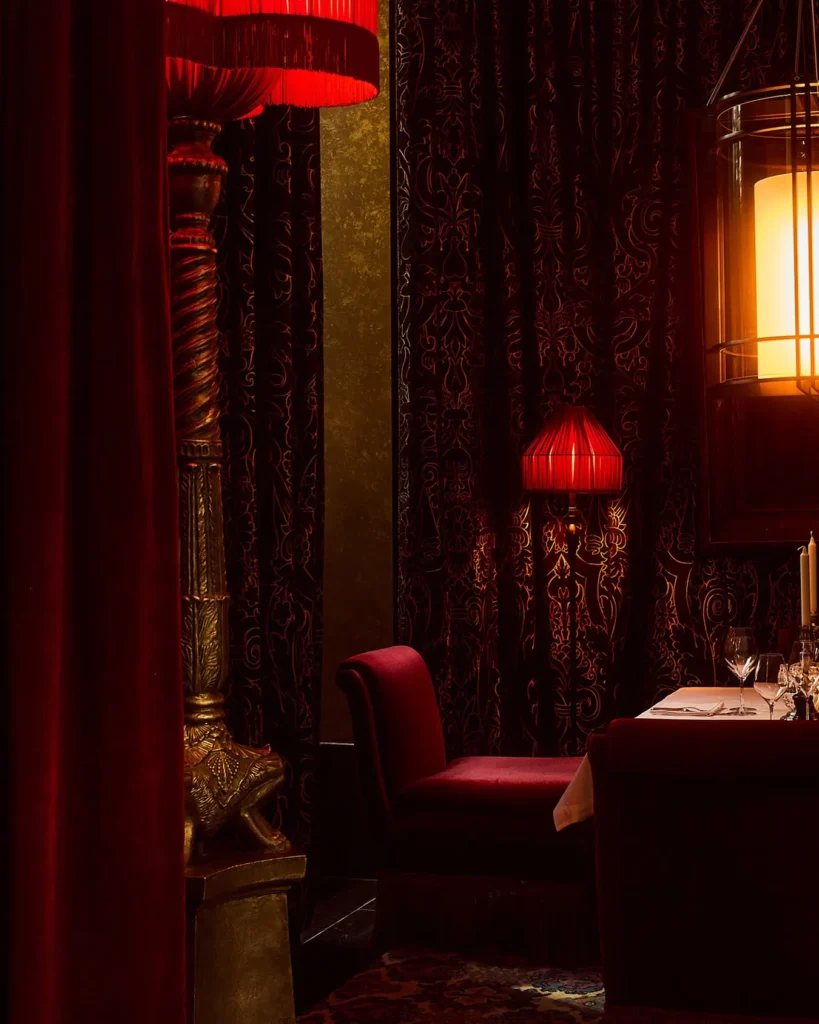 Intimate red dining room with velvet seating at Hotel Costes Paris
