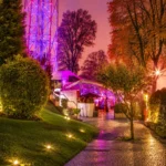 Garden walkway leading to JustMe Milano illuminated at night