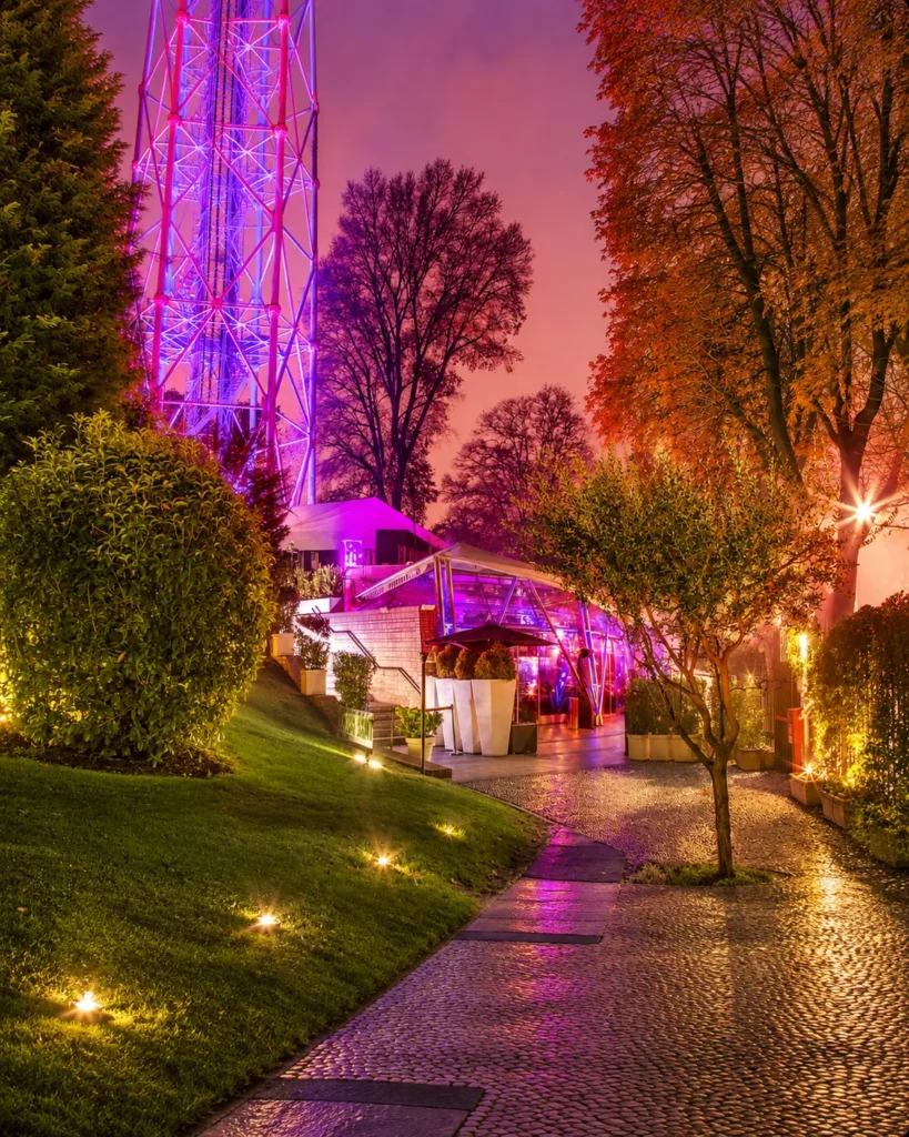 Garden walkway leading to JustMe Milano illuminated at night