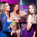 Guests posing with drinks inside JustMe Milano