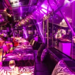 Purple-lit restaurant interior at JustMe Milano
