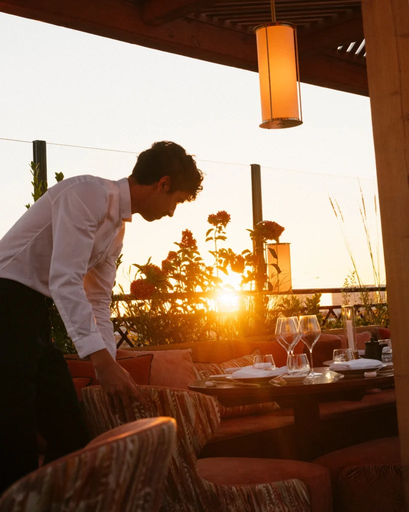 Server setting a table during sunset at Kinugawa Rive Gauche