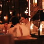 Guests dining in the warm candlelit interior of La Ferme Saint-Amour Courchevel