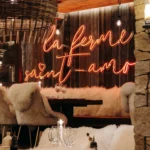 Rustic luxury dining room with a La Ferme Saint-Amour sign in Courchevel