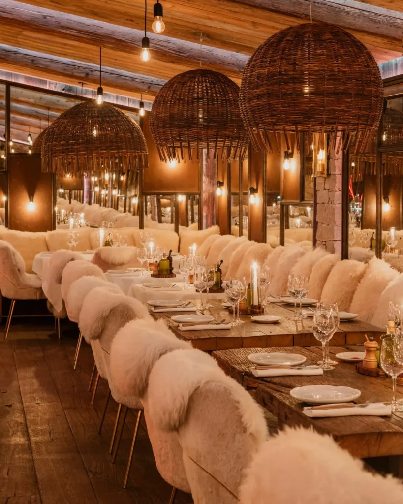 Elegant dining room with rattan pendant lights at La Ferme Saint-Amour Courchevel