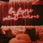 La Ferme Saint-Amour neon sign above a cozy dining area in Courchevel