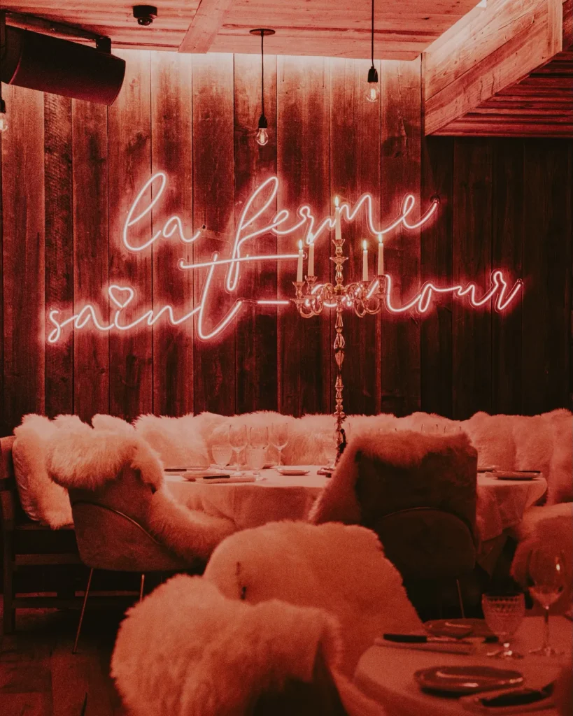 La Ferme Saint-Amour neon sign above a cozy dining area in Courchevel