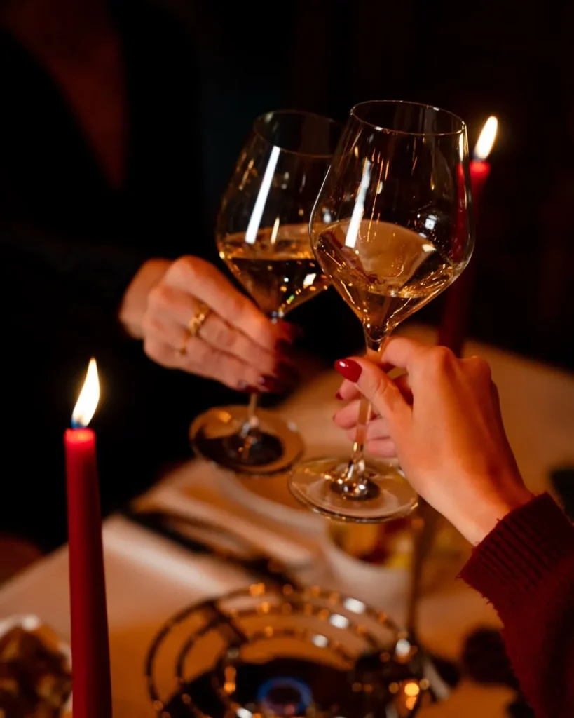 Guests raising wine glasses during dinner at La Ferme Saint-Amour Courchevel