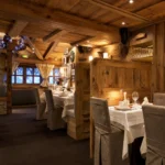 Warmly lit restaurant interior with alpine decor at La Saulire Courchevel