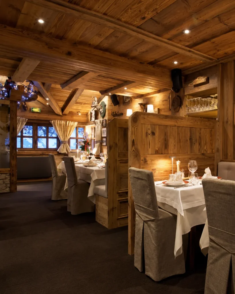 Warmly lit restaurant interior with alpine decor at La Saulire Courchevel