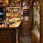 Wine and spirits displayed in the wooden cellar at La Saulire Courchevel