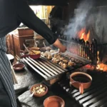 Chef preparing food over an open fire at La Soucoupe Courchevel