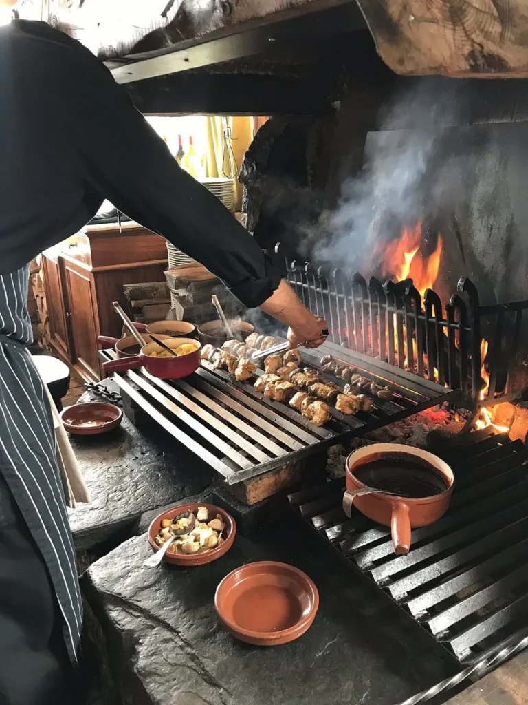 Chef preparing food over an open fire at La Soucoupe Courchevel